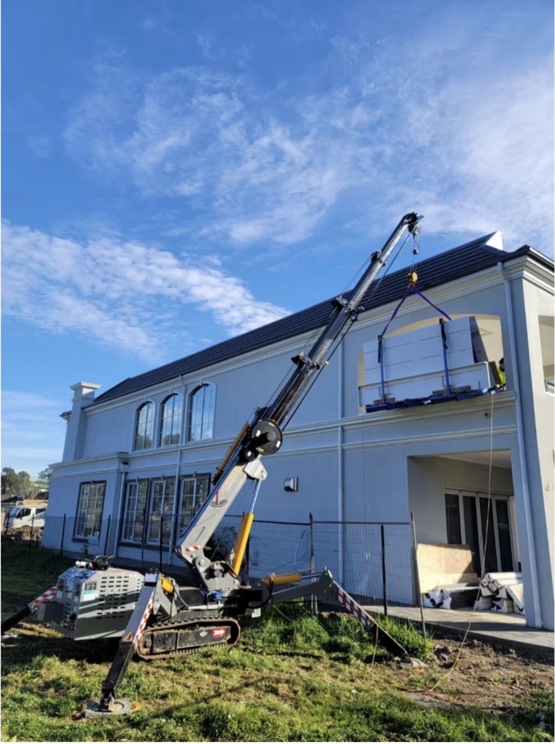 Spider crane lifting materials to upper level balcony